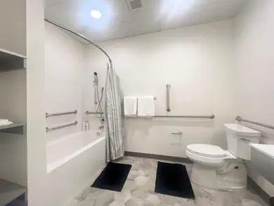 a white bathroom with a toilet and a bath tub at 411 Modern Brand New Studio Apartment in Old Bridge