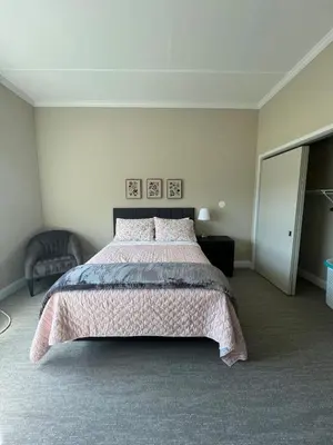 a bedroom with a large bed with a pink bedspread at 410 Modern Brand New Studio Apartment in Old Bridge