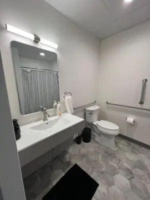 a bathroom with a sink and a toilet and a mirror at 410 Modern Brand New Studio Apartment in Old Bridge