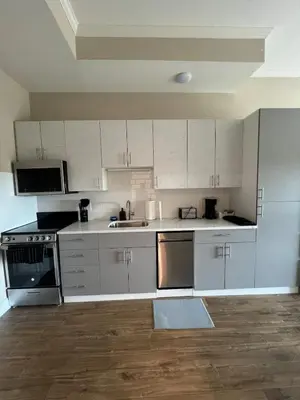 a kitchen with white cabinets and stainless steel appliances at 410 Modern Brand New Studio Apartment in Old Bridge