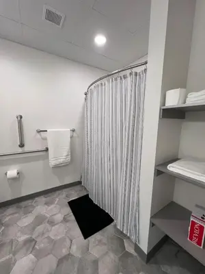 a bathroom with a shower with a striped shower curtain at 410 Modern Brand New Studio Apartment in Old Bridge
