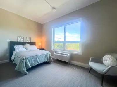 a bedroom with a bed and a window and a chair at 409 Modern Brand New Studio Apartment in Old Bridge
