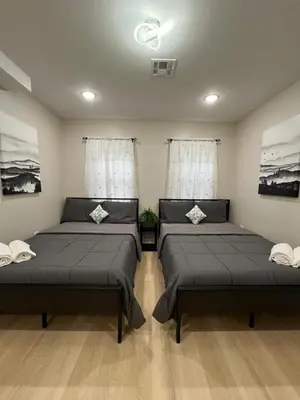 two beds in a room with two windows at Modern 2BR and Office Near NYC With Parking - Sleeps 6 in Jersey City