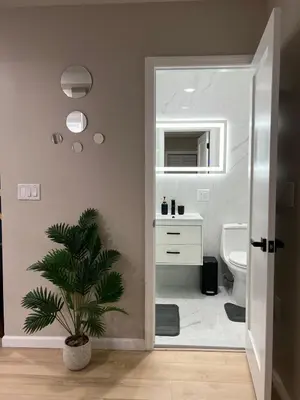 a bathroom with a toilet and a sink and a plant at Modern 2BR and Office Near NYC With Parking - Sleeps 6 in Jersey City