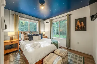 a bedroom with a large bed with a blue ceiling at Pocono Lake Getaway Sauna Hot Tub Playground in Wagners Forest Park