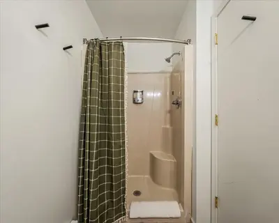 a shower with a shower curtain in a bathroom at Pocono Lake Getaway Sauna Hot Tub Playground in Wagners Forest Park