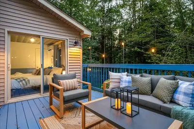 a patio with a couch and a bed in a bedroom at Pocono Lake Getaway Sauna Hot Tub Playground in Wagners Forest Park