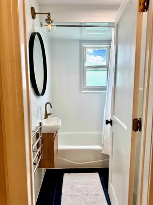 a bathroom with a sink and a bath tub at 20 min NYC-Modern Private Room-Queen Bed-Parking Available But Confirm with Hosts in Jersey City