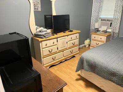 a bedroom with a bed and a dresser with a mirror at Comfy PR near UHS Wilson and BU in Johnson City
