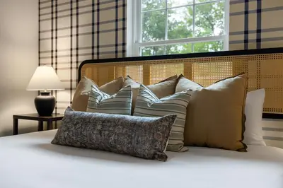 a pile of pillows on a bed with a window at Best Deal in the Poconos! in Tobyhanna