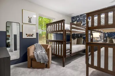 a bedroom with three bunk beds and a chair at Best Deal in the Poconos! in Tobyhanna