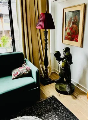 a living room with a lamp and a statue next to a couch at Heart of Fishtown with parking! in Philadelphia