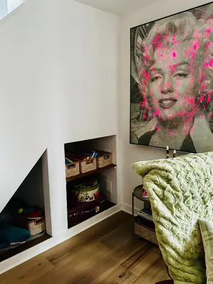 a living room with a couch and a painting on the wall at Heart of Fishtown with parking! in Philadelphia