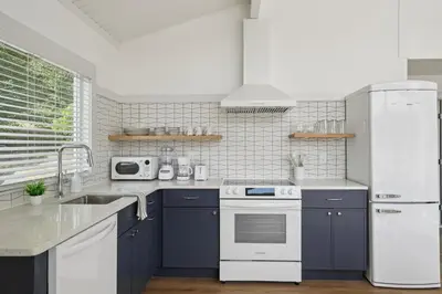 a kitchen with blue cabinets and a white refrigerator at Lakelyn Lodge in Lakeville