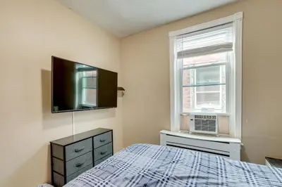 a bedroom with a bed and a flat screen tv at Private Backyard Jawn! Multi-Level Philly Rowhouse in Philadelphia