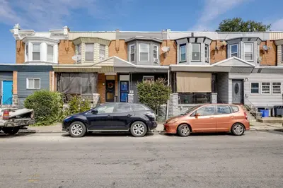 two cars parked in front of a house at Private Backyard Jawn! Multi-Level Philly Rowhouse in Philadelphia