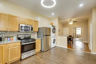 a kitchen with stainless steel appliances and wooden cabinets at Private Backyard Jawn! Multi-Level Philly Rowhouse in Philadelphia