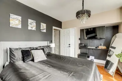 a bedroom with a bed and a chandelier at Private Backyard Jawn! Multi-Level Philly Rowhouse in Philadelphia