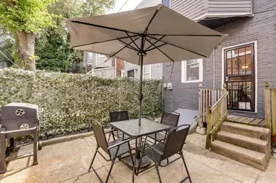 a table and chairs with an umbrella on a patio at Private Backyard Jawn! Multi-Level Philly Rowhouse in Philadelphia