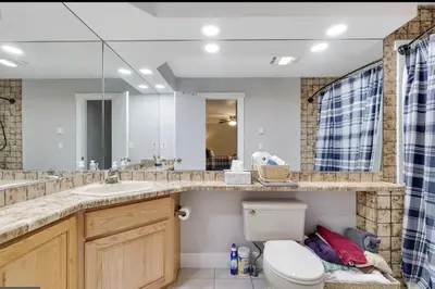 a bathroom with a toilet and a sink and a mirror at Amazing Condo with hot tub and screened in porch 8 passes to lake and beach in Stoddartsville