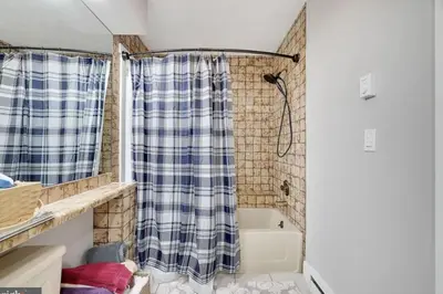 a bathroom with a blue and white shower curtain at Amazing Condo with hot tub and screened in porch 8 passes to lake and beach in Stoddartsville