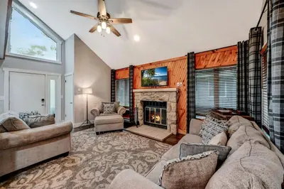 a living room with a couch and a fireplace at Amazing Condo with hot tub and screened in porch 8 passes to lake and beach in Stoddartsville