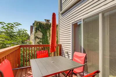 a table and chairs on a balcony with a umbrella at Remote Work Hub Philly Condo 3 Mi to Center City! in Philadelphia