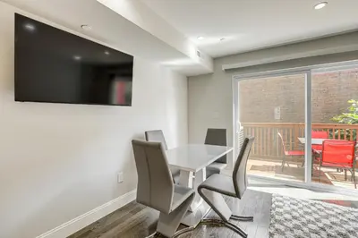 a dining room with a table and chairs and a balcony at Remote Work Hub Philly Condo 3 Mi to Center City! in Philadelphia