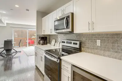 a kitchen with white cabinets and a microwave at Remote Work Hub Philly Condo 3 Mi to Center City! in Philadelphia