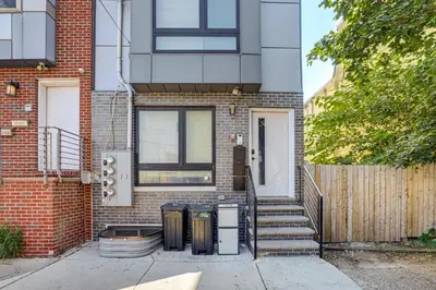 a brick house with two trash cans in front of it at Remote Work Hub Philly Condo 3 Mi to Center City! in Philadelphia