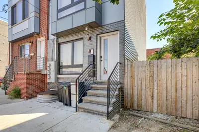a home with a wooden fence in front of it at Remote Work Hub Philly Condo 3 Mi to Center City! in Philadelphia