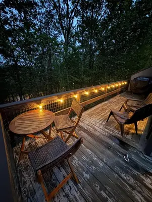 a wooden deck with a table and chairs and lights at 108 Escape: Ski-In, Chill-Out |Waterparks & Hiking in Tannersville