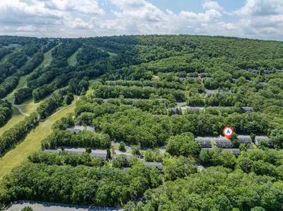 an aerial view of a forest of trees with a red circle at 108 Escape: Ski-In, Chill-Out |Waterparks & Hiking in Tannersville