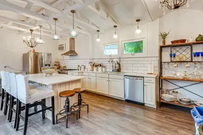 a kitchen with white cabinets and a table and chairs at A Retreat in an Historic Estate with Modern Comforts in Scranton