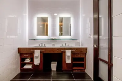 a bathroom with a sink and two mirrors at Mint House 70 Pine by Kasa in New York