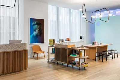a living room with a desk and a table with chairs at Mint House 70 Pine by Kasa in New York