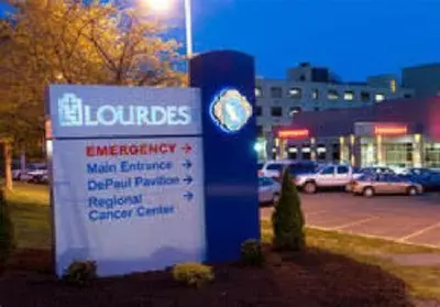 a sign in front of a parking lot with cars at Spacious, Unique PR near Binghamton University in Johnson City