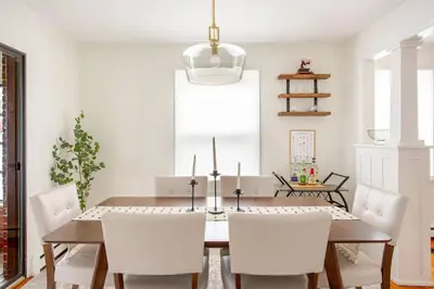 a dining room with a wooden table and white chairs at Elegant Spacious Retreat Perfect For Families in Wilmington