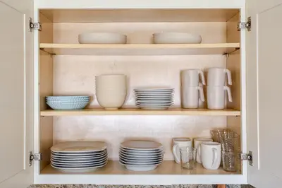 a cabinet filled with plates and bowls and dishes at Elegant Spacious Retreat Perfect For Families in Wilmington