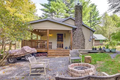 a small house with a fire pit in front of it at Ski, Swim, Relax Old-Fashioned Poconos Getaway in Pocono Pines