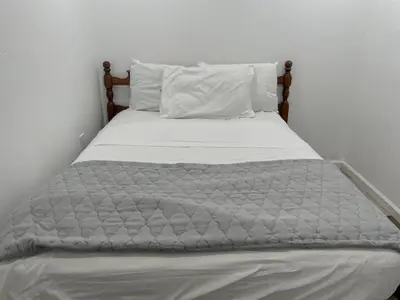 a bed with a gray comforter and pillows at 1711 Edgley Street in Philadelphia