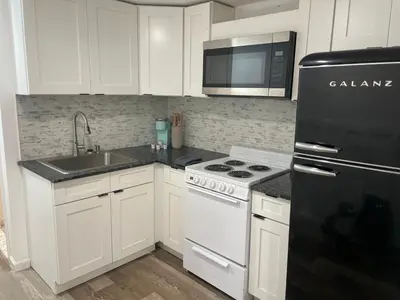 a kitchen with white cabinets and a black refrigerator at 1711 Edgley Street in Philadelphia