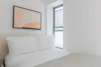 a bedroom with a bed and a framed picture on the wall at Blueground Alphabet City view nr Tompkins Sq Park NYC-1884 in New York