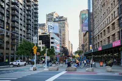 a busy city street with people crossing a crosswalk at Blueground Chelsea rooftop nr Highline NYC-369 in New York