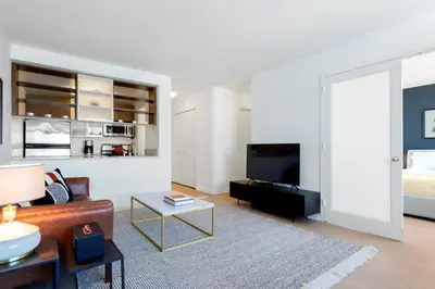 a living room with a couch and a tv at Blueground Chelsea rooftop nr Highline NYC-369 in New York