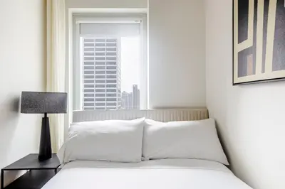 a bedroom with a white bed and a window at Blueground Midtown South rooftop nr Bryant Park NYC-2028 in New York