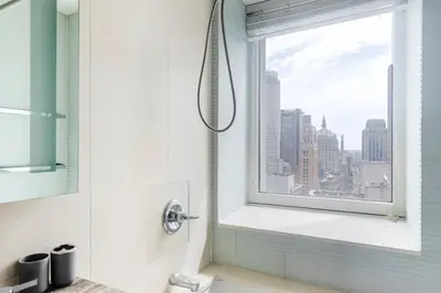 a shower in a bathroom with a window at Blueground Midtown South rooftop nr Bryant Park NYC-2028 in New York