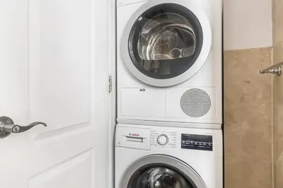 a washing machine and a washer and dryer in a bathroom at Blueground Nolita private entrance nr Bowery NYC-2054 in New York