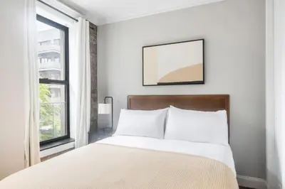 a white bedroom with a bed and a window at Blueground Nolita private entrance nr Bowery NYC-2054 in New York
