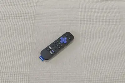 a remote control sitting on top of a bed at The Bella Vista Townhouse in Philadelphia